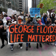 Protesters hold signs as they march during a protest over the death of George Floyd in Chicago on May 30, 2020.